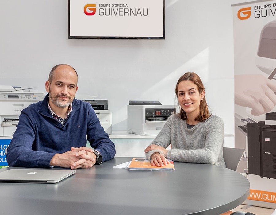 Dos personas del equipo de Guivernau Equips en la mesa de reuniones de su oficina de Tarragona
