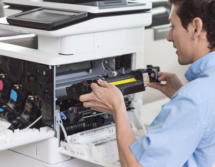 Técnico sustituyendo un componente de una impresora multifunción